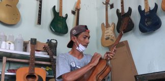 Muhammad Andik Gunawan melakukan proses finishing gitar elektrik di Dusun Ngundo, Desa Candimulyo, Kecamatan/Kabupaten Jombang. IM.com/Karimatul Maslahah/