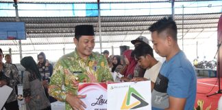 Plt Bupati Sidoarjo Subandi menyerahkan bantuan DBHCHT ke buruh pabrik rokok, Kamis (30/5/2024). IM.com/Yoga/