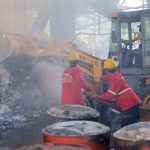 Petugas melakukan pembasahan di gudang limbah kertas di Mojokerto yang terbakar, Selasa (11/6/2024). IM.com/Erik/