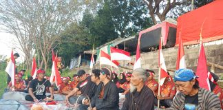 Para anggota Yayasan Jogo Brantas saat berdoa bersama sebelum melaksanakan larung sesaji di tengah Sungai Brantas, Sabtu (6/7/2024). IM.com/Tyan/