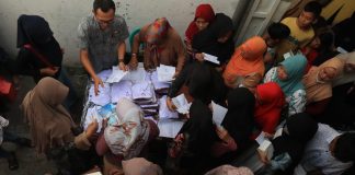 Warga antre mengambil seragam sekolah gratis yang dibagikan Pemdes Kepatihan Jombang, Kamis (11/7/2024). IM.com/Karimatul Maslahah/