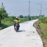 Warga melintas di jalan rabat beton yang dibangun Satgas TMMD Kodim Mojokerto.