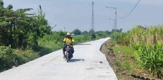 Warga melintas di jalan rabat beton yang dibangun Satgas TMMD Kodim Mojokerto.