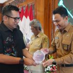 Pj Wali Kota Mojokerto M Ali Kuncoro (kiri) menyerahkan piala Lurah Gunung Gedangan.