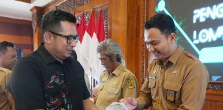 Pj Wali Kota Mojokerto M Ali Kuncoro (kiri) menyerahkan piala Lurah Gunung Gedangan.