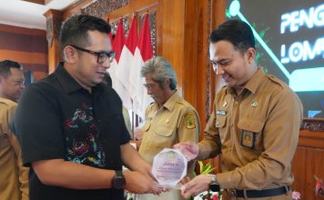 Pj Wali Kota Mojokerto M Ali Kuncoro (kiri) menyerahkan piala Lurah Gunung Gedangan.