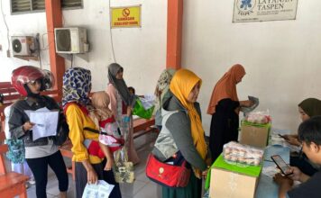 Keluarga penerima manfaat menerima bantuan pangan di kantor pos Kota Mojokerto, Kamis (12/9/2024).