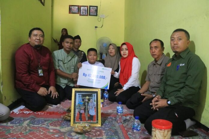 Bupati Mojokerto, Ikfina Fahmawati (ketiga kanan) menyalurkan santunan dari BPJS Ketenagakerjaan.