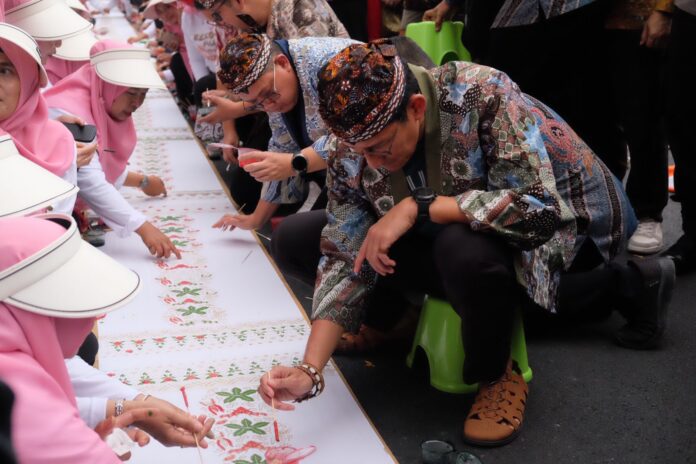 Sandiaga Salahuddin Uno ikut serta mewarnai batik rekor muri di Jalan Hayam Wuruk, Magersari Kota Mojokerto, Selasa (15/10/2024)