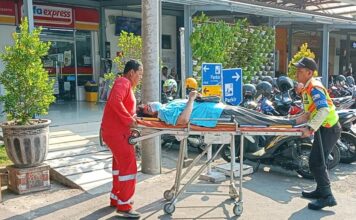 Petugas saat mengevakuasi penumpang KA yang pingsan di stasiun Mojokerto, Senin (28/10/2024).