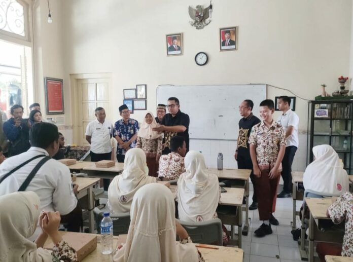 Siswa SMPN 2 Kota Mojokerto bersama Pj. Walikota Mojokerto, M. Ali Kuncoro saat menikmati hidangan Makan Bergizi Gratis