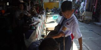 Penjahit mengukur seragam sekolah di Kota Mojokerto. IM.com/Karimatul Maslahah/