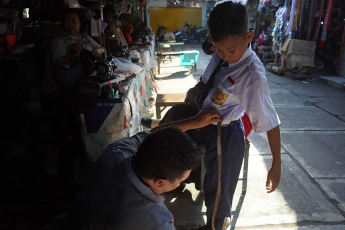 Penjahit mengukur seragam sekolah di Kota Mojokerto. IM.com/Karimatul Maslahah/