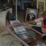 Rony melakukan proses finishing pigura di Kota Mojokerto. IM.com/Karimatul Maslahah/
