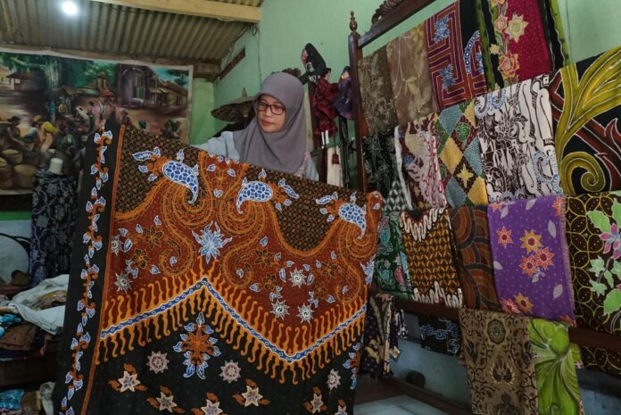 Sri Mujiatin pemilik butik Batik Cempaka saat menunjukkan hasil karyanya. IM.com/Karimatul Maslahah/