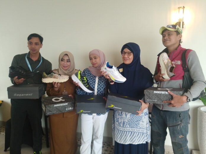 Souvenir: Produsen sepatu di Kota Mojokerto memberikan souvenir pada Selliane Halua Ishak (hijab hitam) yang mewakili Menteri Ekonomi Kreatif pada seminar Skill Up Lab di hotel Aston Mojokerto (20/10/2025).