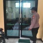 Petugas kepolisian melakukan olah TKP di balai Desa Buncitan Sedati Sidoarjo terkait temuan kepala desa meninggal dunia