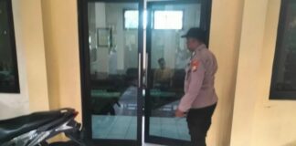 Petugas kepolisian melakukan olah TKP di balai Desa Buncitan Sedati Sidoarjo terkait temuan kepala desa meninggal dunia
