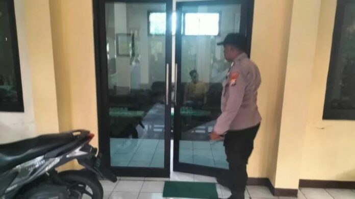 Petugas kepolisian melakukan olah TKP di balai Desa Buncitan Sedati Sidoarjo terkait temuan kepala desa meninggal dunia