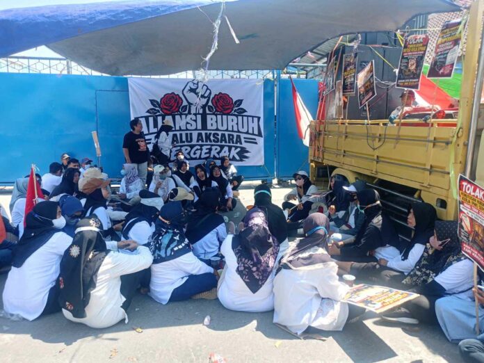 Puluhan buruh PT Alu Aksara Pratama Mojokerto menggelar demo memprotes dugaan PHK sepihak, mutasi, outsourcing, dan PP kedaluwarsa.