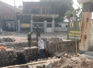 Di Bawah Terik Matahari, TNI dan Warga Bangun Jembatan Penghubung