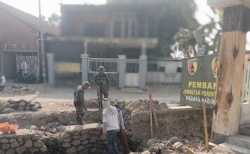 Di Bawah Terik Matahari, TNI dan Warga Bangun Jembatan Penghubung